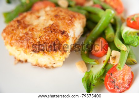 Closeup of Cod Fried  in Coconut Flakes Served with Sauteed Bock Choy, Green Beans and Tomatoes