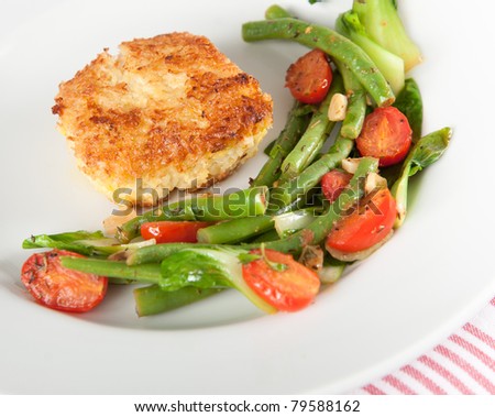 Closeup of Cod Fried  in Coconut Flakes Served with Sauteed Bok Choy, Green Beans and Tomatoes