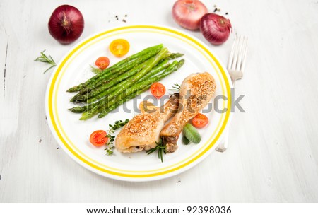 Grilled Chicken Drumsticks Served with Young Asparagus and Tomatoes