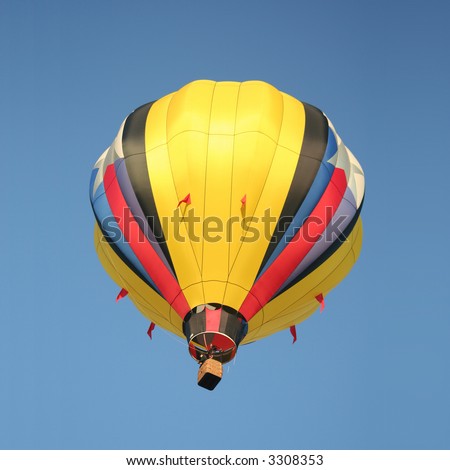 A Bright Yellow Hot Air Balloon Drifting Through a Clear Blue Sky