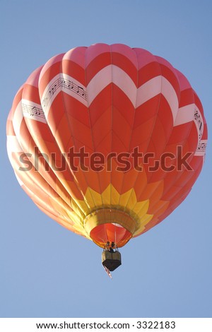 A Red Hot Air Balloon Lifts Off into the Clear Blue Morning Sky