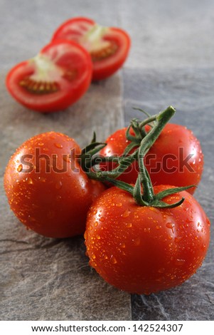 Ripe tomatoes on a gray slate stone.
