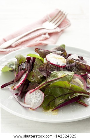 Radish salad with red onion and rocket leaves.