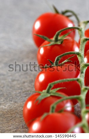 Red cherry tomatoes on a gray slate stone