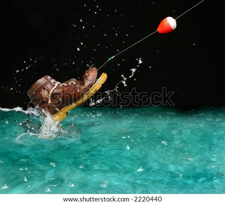 Catching an old shoe with a fishing pole. Splash of water