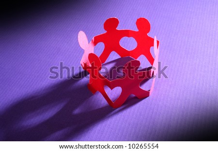 Paper people holding hands together making heart shapes