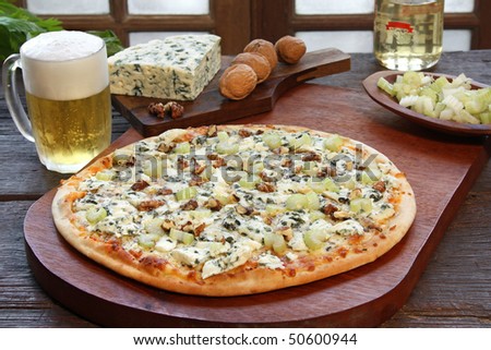 Blue cheese pizza with a glass of beer and some ingredients
