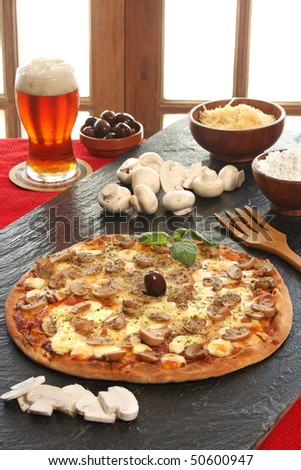 Mushroom pizza with a glass of beer and ingredients