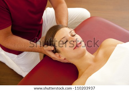 head and neck massage of a beautiful woman. a woman receives a head and neck pressure point massage by her chiropractor