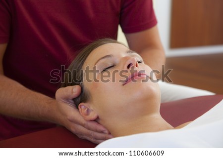 head and neck massage of a beautiful woman. a woman receives a head and neck pressure point massage by her chiropractor