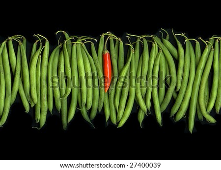 Organic string-beans and hot Thai pepper against a dramatic black background.