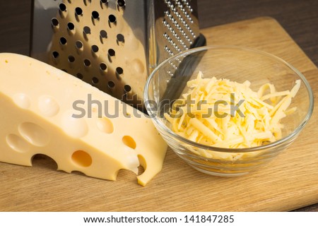 Grated Cheese on cutting board with grater