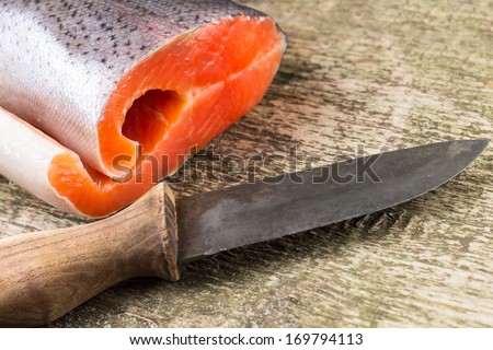 Fresh Salmon on rustic weathered wooden board with knife