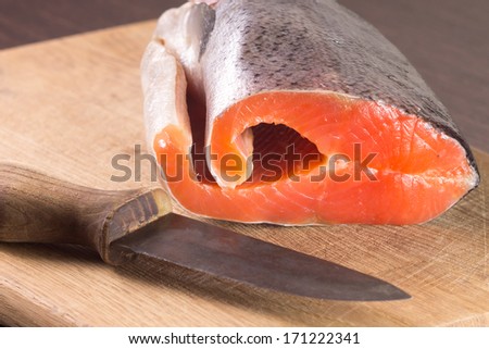 Fresh Salmon with knife on cutting board
