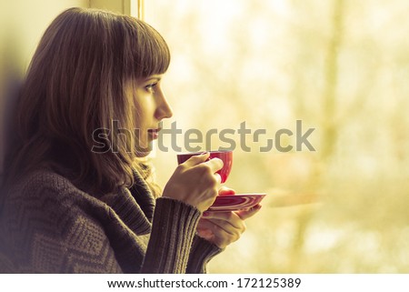 Coffee. Pretty Girl Drinking Coffee Or Tea Near Window. Warm Colors Toned