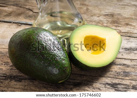 Whole and cut in half Avocado with oil