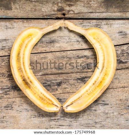 Cut in Half Banana lying on Textured Weathered Wooden Table