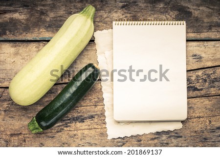 Warm color toned series of Vegetables with recipe book on wooden table. Old wood background. Menu background. Squash