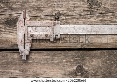 Close up image of old vernier caliper on wood background. Top view old tool