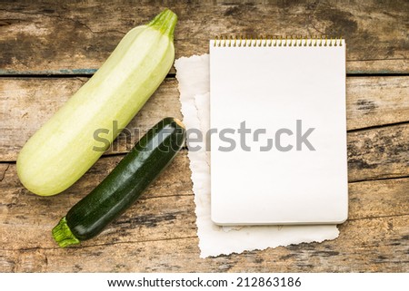 Menu background. Vegetables on table with cook book. Cooking with recipe book. Squash.