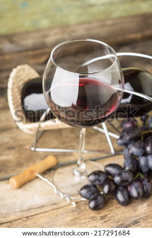 Winery menu background. Red wine with cluster od ripe fresh blue grapes and corkscrew lying on table