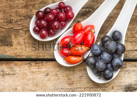 Fresh autumn berries on old wood table. Healthy eating food background