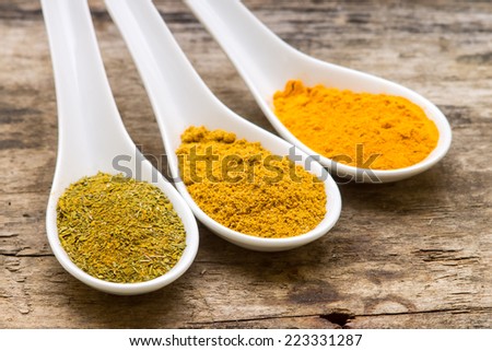 Spicy background. Variety of spices powder on wooden table