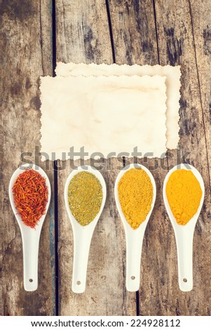 Spices recipe background. Vertical composition of variety of seasoning with vintage paper card. Top View