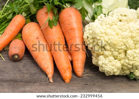 Fresh vegetables on wooden table. Harvesting background. Carrots and cauliflower