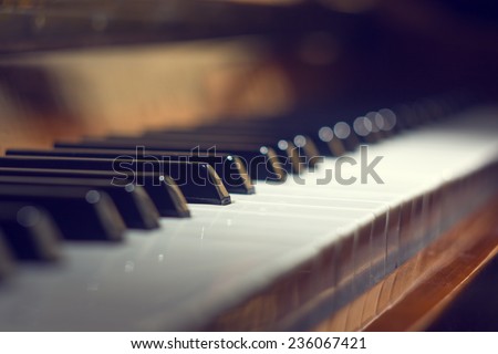 Piano keyboard background with selective focus. Warm color toned image