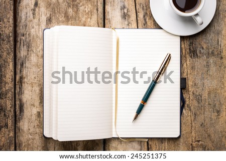 Notebook with elegant fountain pen and cup of espresso. Top view of writer\'s workplace