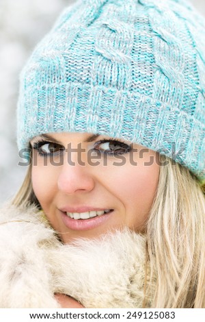 Young smiling cheerfull caucasian girl looking into camera. Beauty blonde woman at winter outdoor
