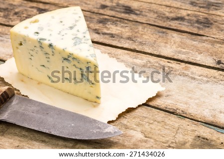 Blue cheese background with copy space. Roquefort cheese with old knife