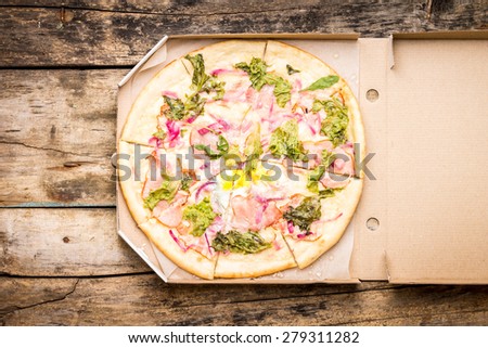 Fast food pizza background. Top view mock up with pizza in box on wooden table.