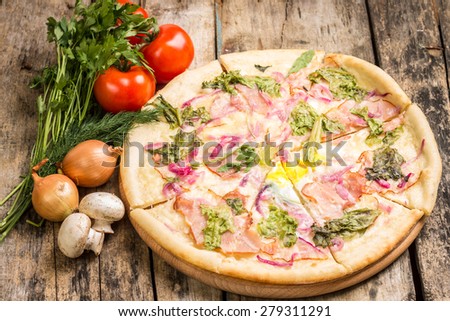 Sliced pizza with vegetables around on wooden table. Recipe and menu pizza background