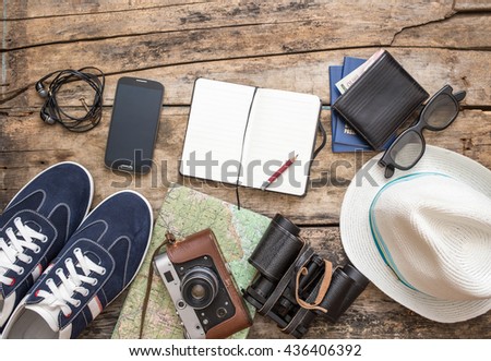 Set of accessories for travel. Shoes, camera, map, notebook on wooden background