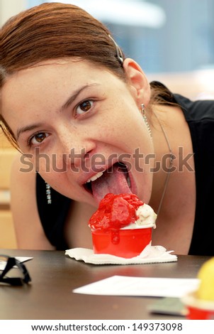 woman portrait eating ice-cream with opened mouth and tongue sticking out