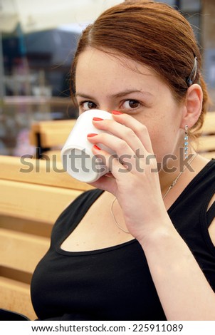 young caucasian brunette woman portrait drinking coffee with cup in hand