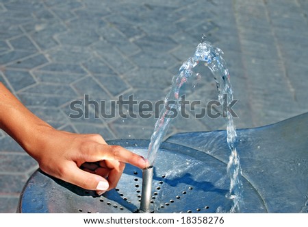 Water drinking fountain with human hand close up