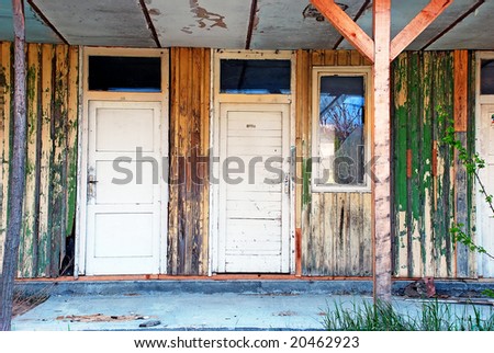 two old wooden white doors broken window of abandoned ruined house