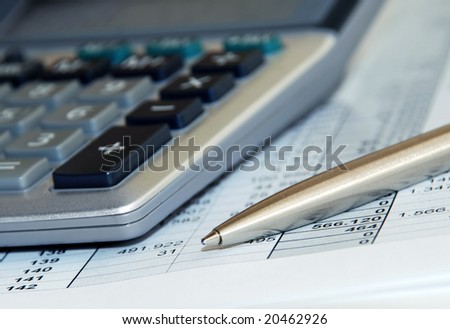 silver calculator with pen and calculations numbers on paper
