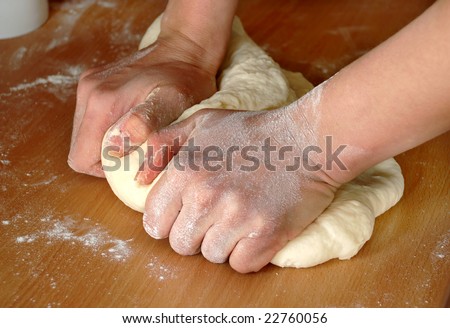 woman hands knead dough on wooden table