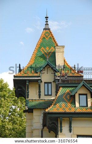high green roof on yellow building over blue sky