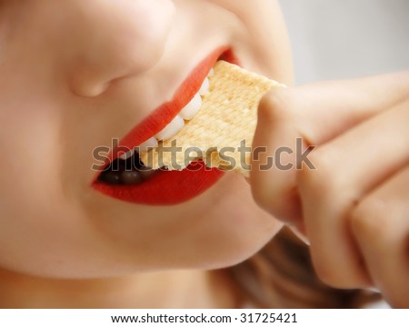 young girl opened mouth biting a cookie