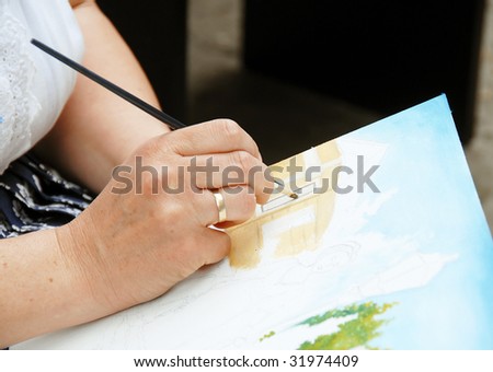 Woman artist hand painting picture on canvas