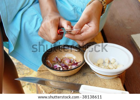 girl hands peeling a garlic with knife in yard outdoor