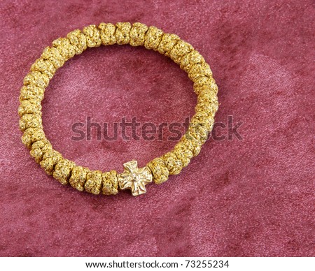 round golden bracelet rosary over purple background