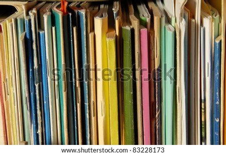 various colorful books and notebooks covers on bookshelf