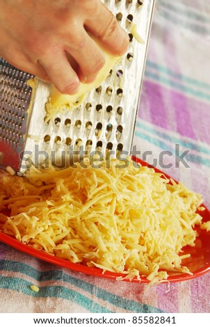 grated yellow cheese with a metal grater closeup