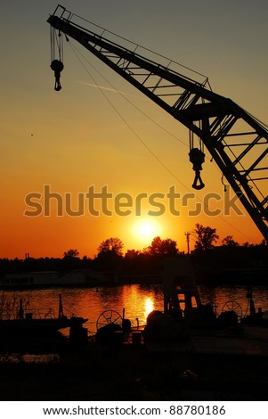 silhouettes on crane in port of Sava river over orange sunset in Belgrade, Serbia